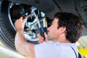 36322262 mechanic working in car workshop on wheel